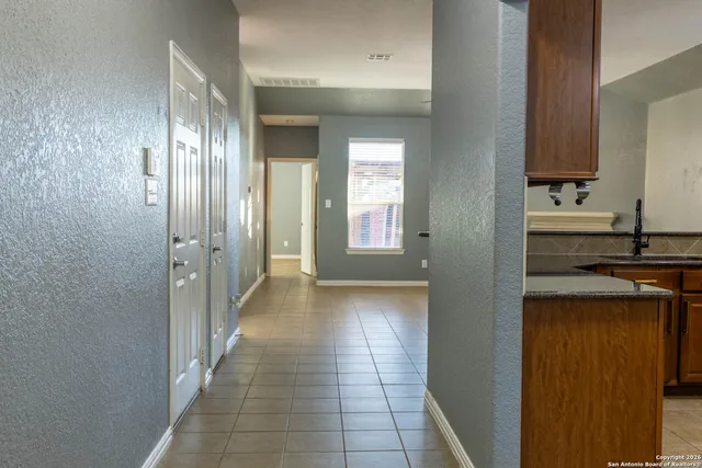 a view of a hallway with wooden floor and a living room