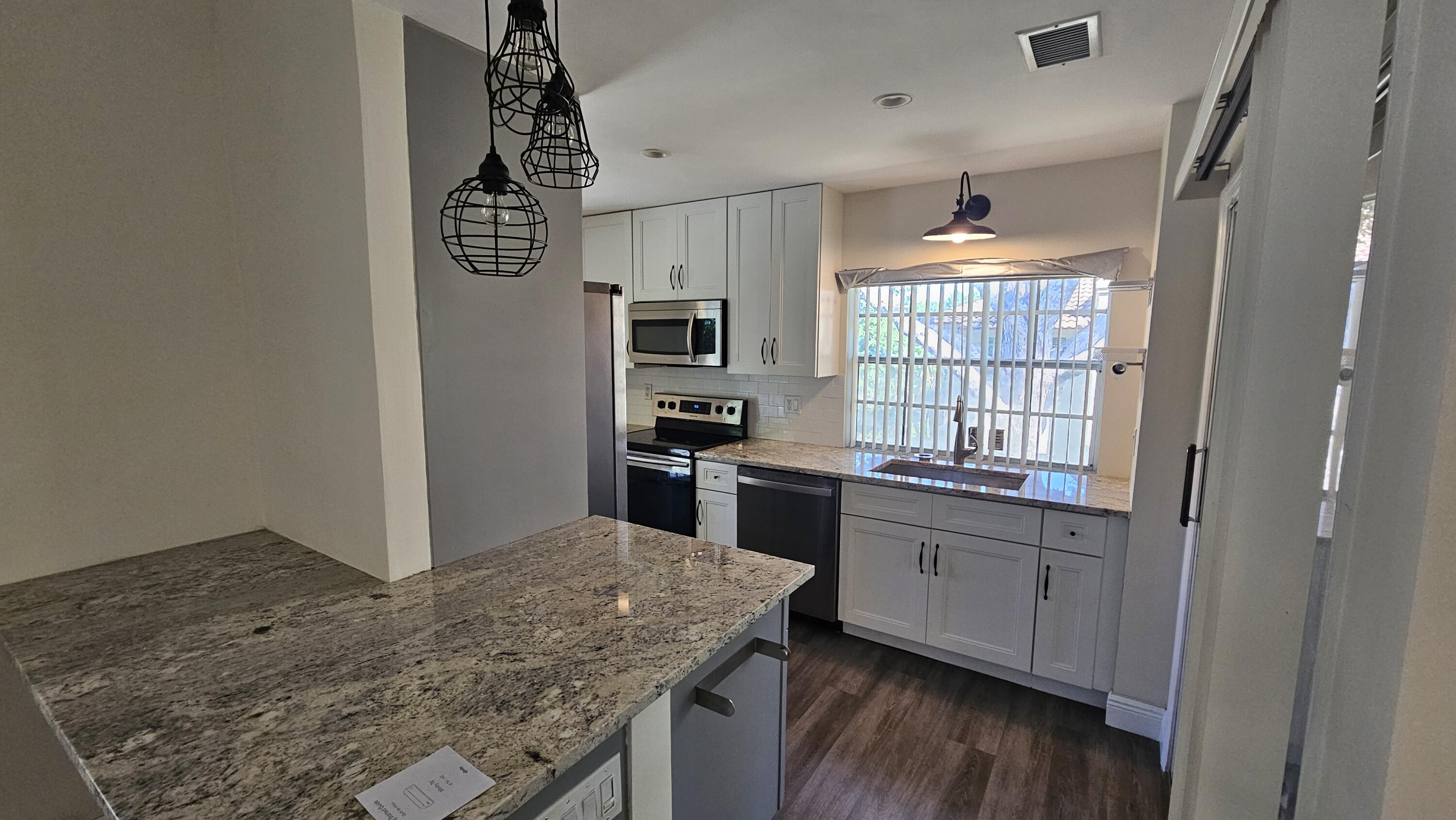 6560 Via Regina Boca Raton, FL 33433 - Photo 12 of 15 a kitchen with granite countertop a stove a sink and a refrigerator