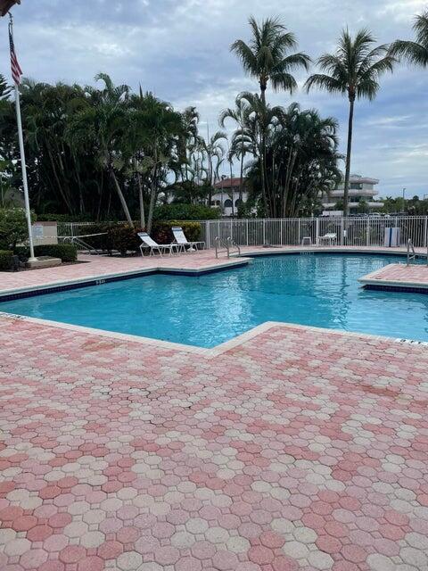 6560 Via Regina Boca Raton, FL 33433 - Photo 2 of 15 a view of a swimming pool with a yard and palm trees