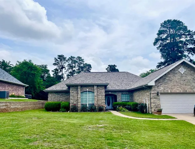 a front view of a house with a garden and yard