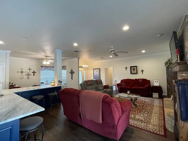 a living room with furniture a flat screen tv and kitchen view