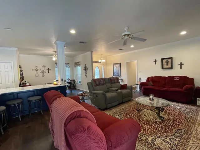a living room with furniture a ceiling fan and a rug