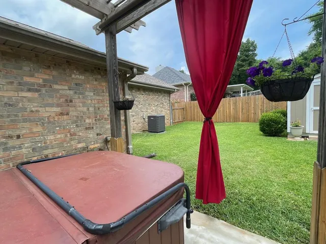 a view of backyard with potted plants and wooden fence
