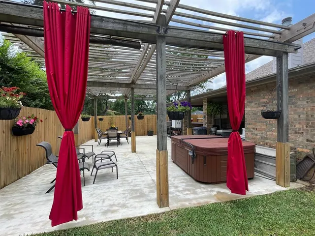 a view of a patio with table and chairs potted plants and floor to ceiling window