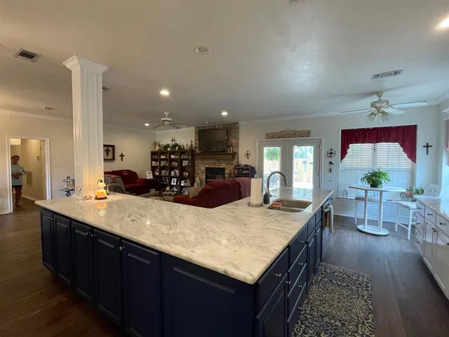 a kitchen with counter top space sink and wooden floor