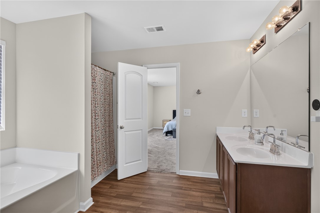 1081 Edenbrooke Circle Anderson, SC 29621 - Photo 28 of 46 A well-appointed bath features a dual vanity and a built-in tub with adjacent shower.