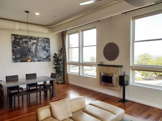 a living room with furniture a fireplace and a large window