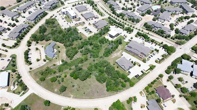 an aerial view of a city with lots of residential buildings and green landscape