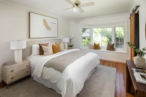 a bedroom with bed and a large window