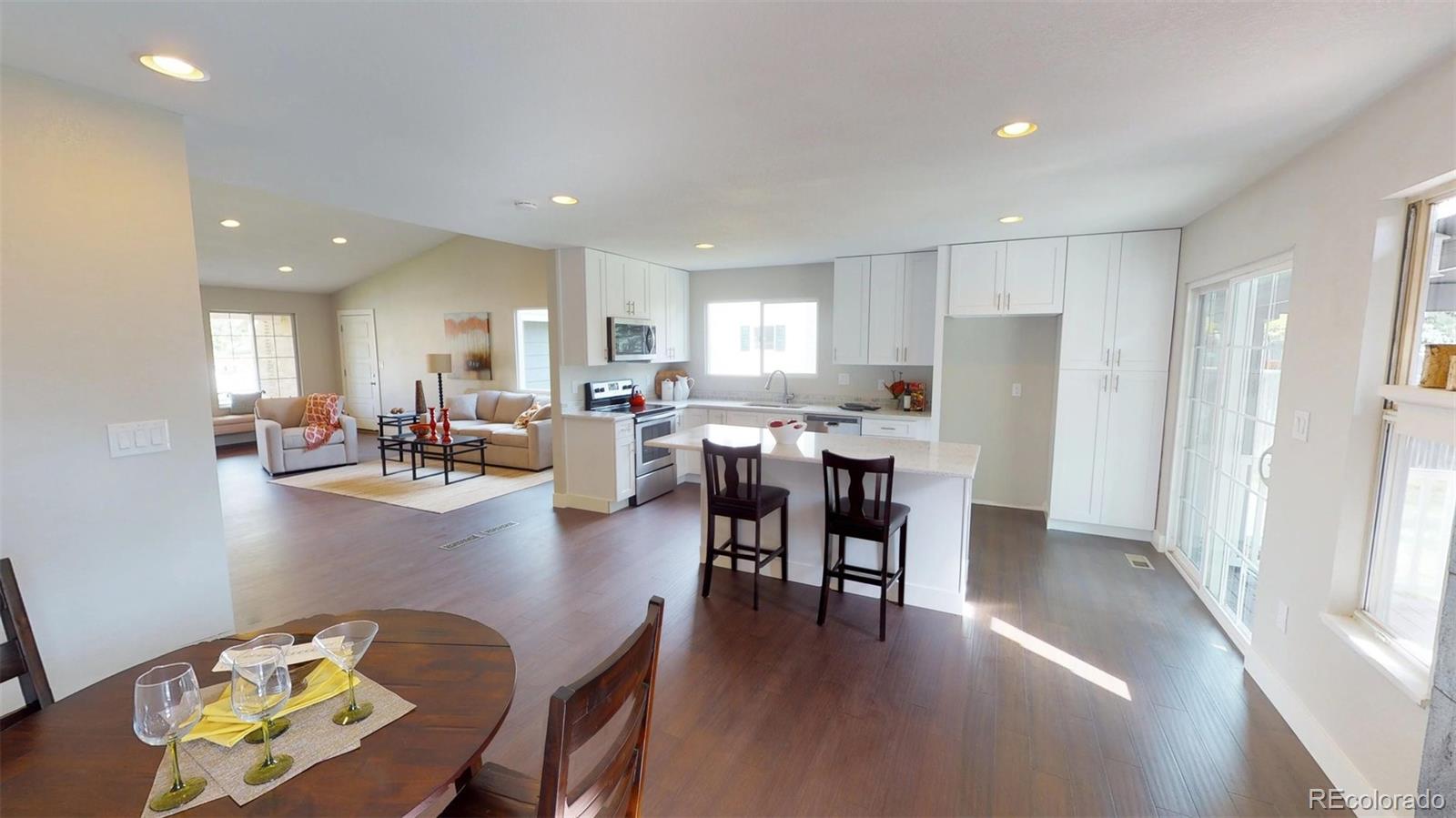 530 Prairie Ridge Road Highlands Ranch, CO 80126 - Photo 4 of 18 a kitchen with a dining table chairs refrigerator and cabinets