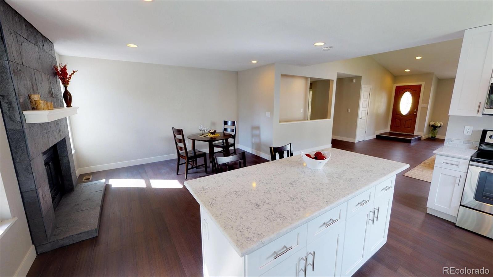 530 Prairie Ridge Road Highlands Ranch, CO 80126 - Photo 5 of 18 a open kitchen with stainless steel appliances granite countertop a stove oven a sink a dining table and chairs with wooden floor