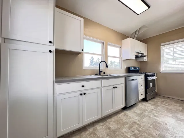 a kitchen with white cabinets and white appliances