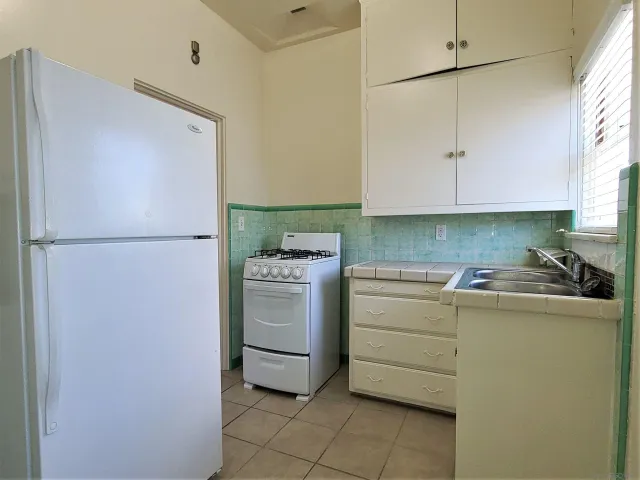 a kitchen with a refrigerator and a stove
