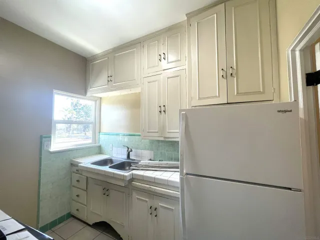 a kitchen with a refrigerator sink and cabinets