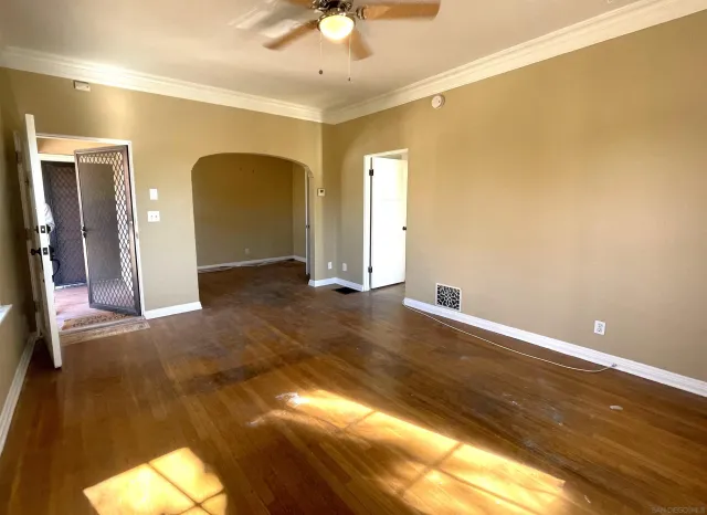 a view of a livingroom with wooden floor and a ceiling fan