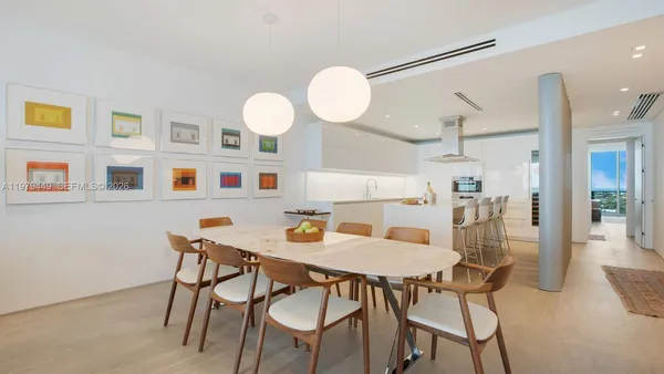 a view of a dining room with furniture and a chandelier fan