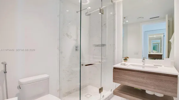 a bathroom with a bathtub shower sink vanity and toilet