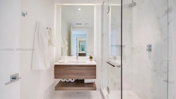a bathroom with a sink mirror and shower