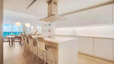 a kitchen with a dining table chairs and white cabinets