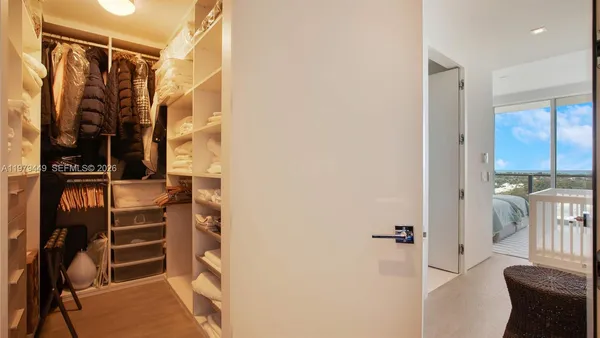 a view of walk in closet with clothes and shoes