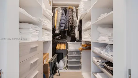 a view of walk in closet with clothes