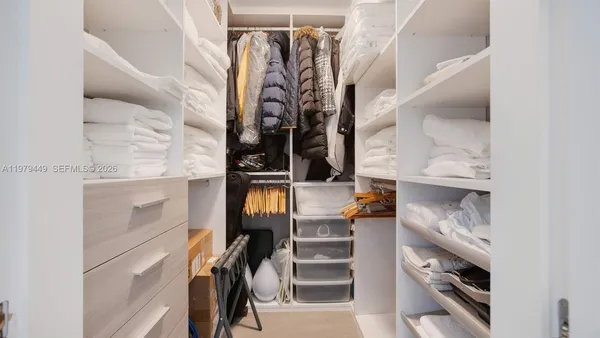 a view of walk in closet with clothes