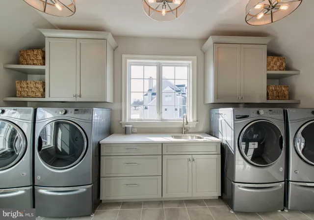 a utility room with sink dryer and washer