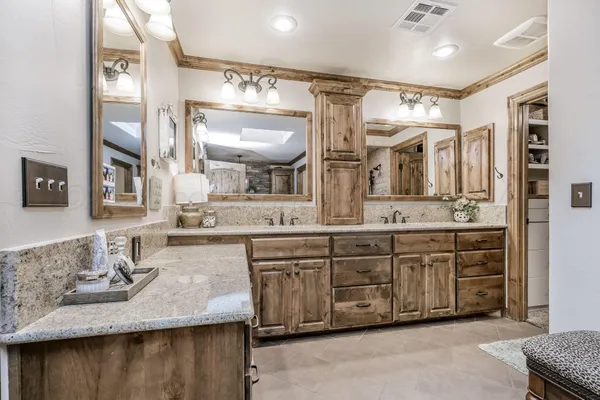 a bathroom with double vanity and a mirror