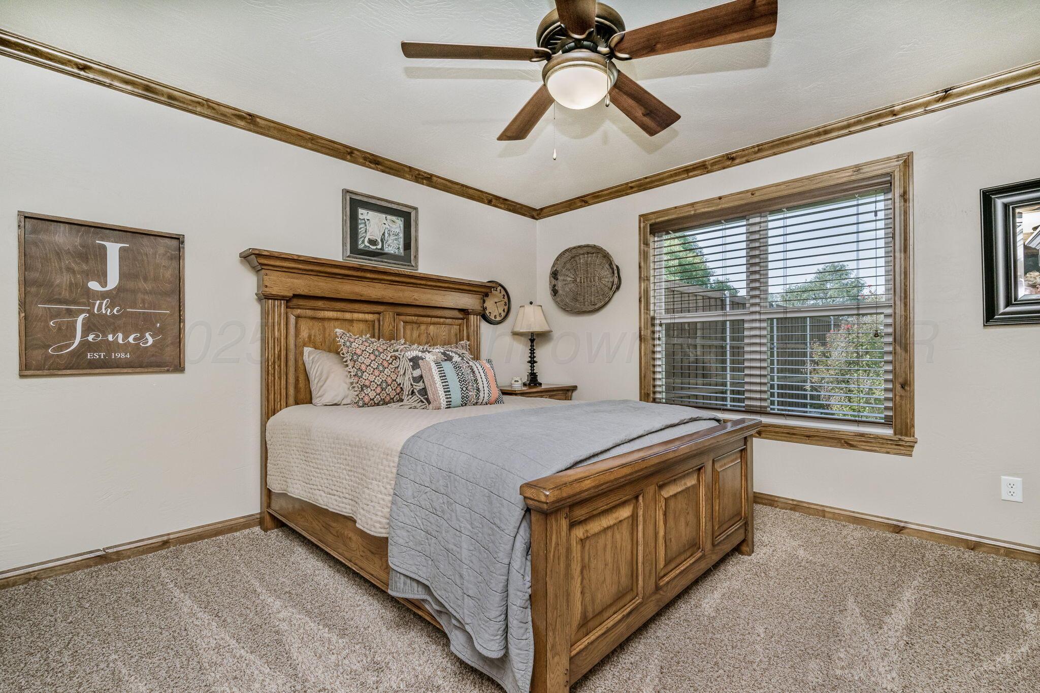 100 Thomas Lane Wheeler, TX 79096 - Photo 22 of 50 a bedroom with a bed and a chandelier