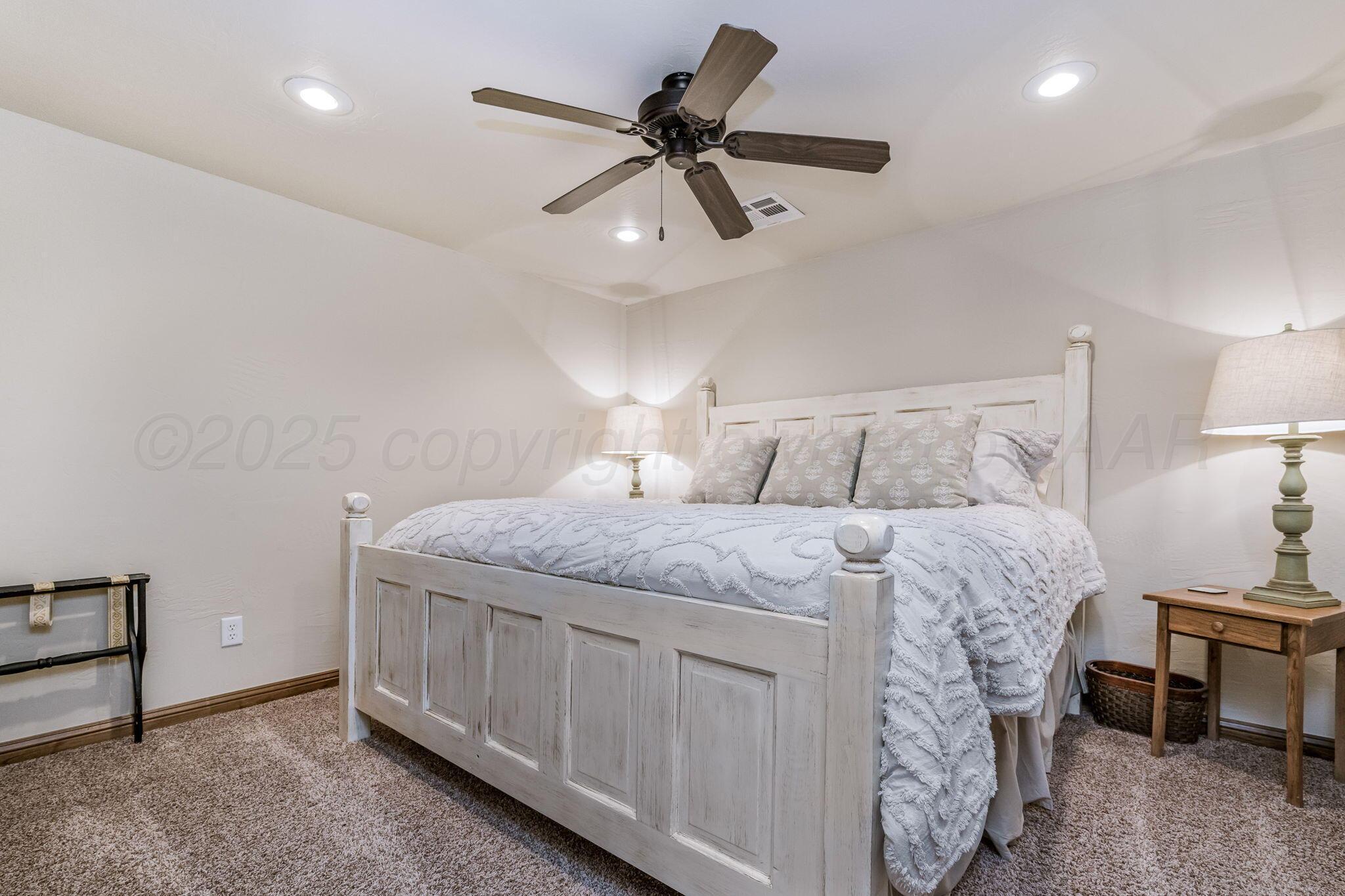 100 Thomas Lane Wheeler, TX 79096 - Photo 25 of 50 a bedroom with a bed and a chandelier