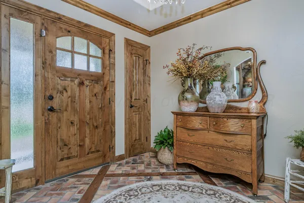 a view of front door with lamp and potted plant