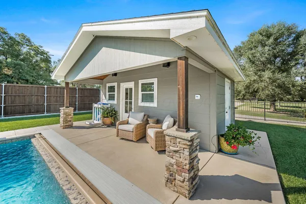 a view of a backyard with table and chairs potted plants