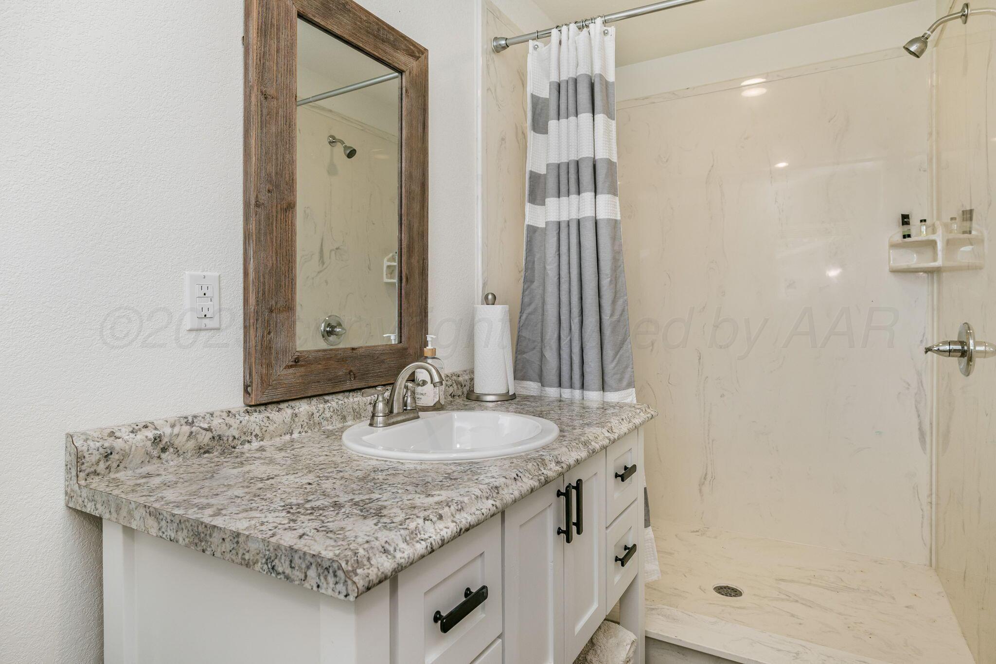 100 Thomas Lane Wheeler, TX 79096 - Photo 34 of 50 a bathroom with a granite countertop sink and a mirror