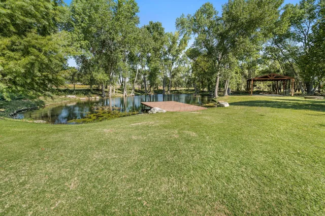 an aerial view of a house with a garden and lake view