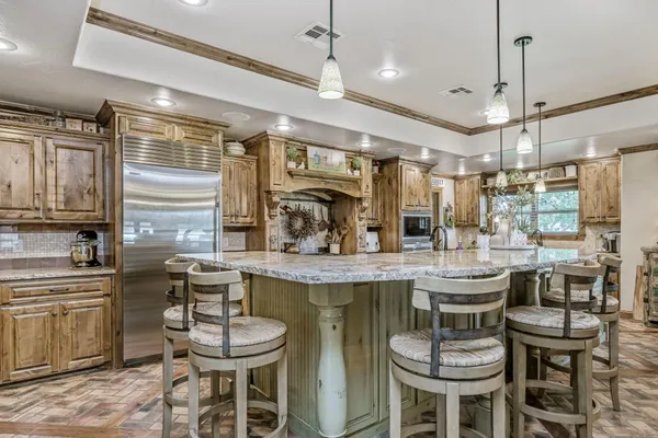 a kitchen with a dining table chairs cabinets and stainless steel appliances