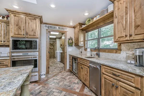 a kitchen with stainless steel appliances granite countertop a stove a sink and a microwave