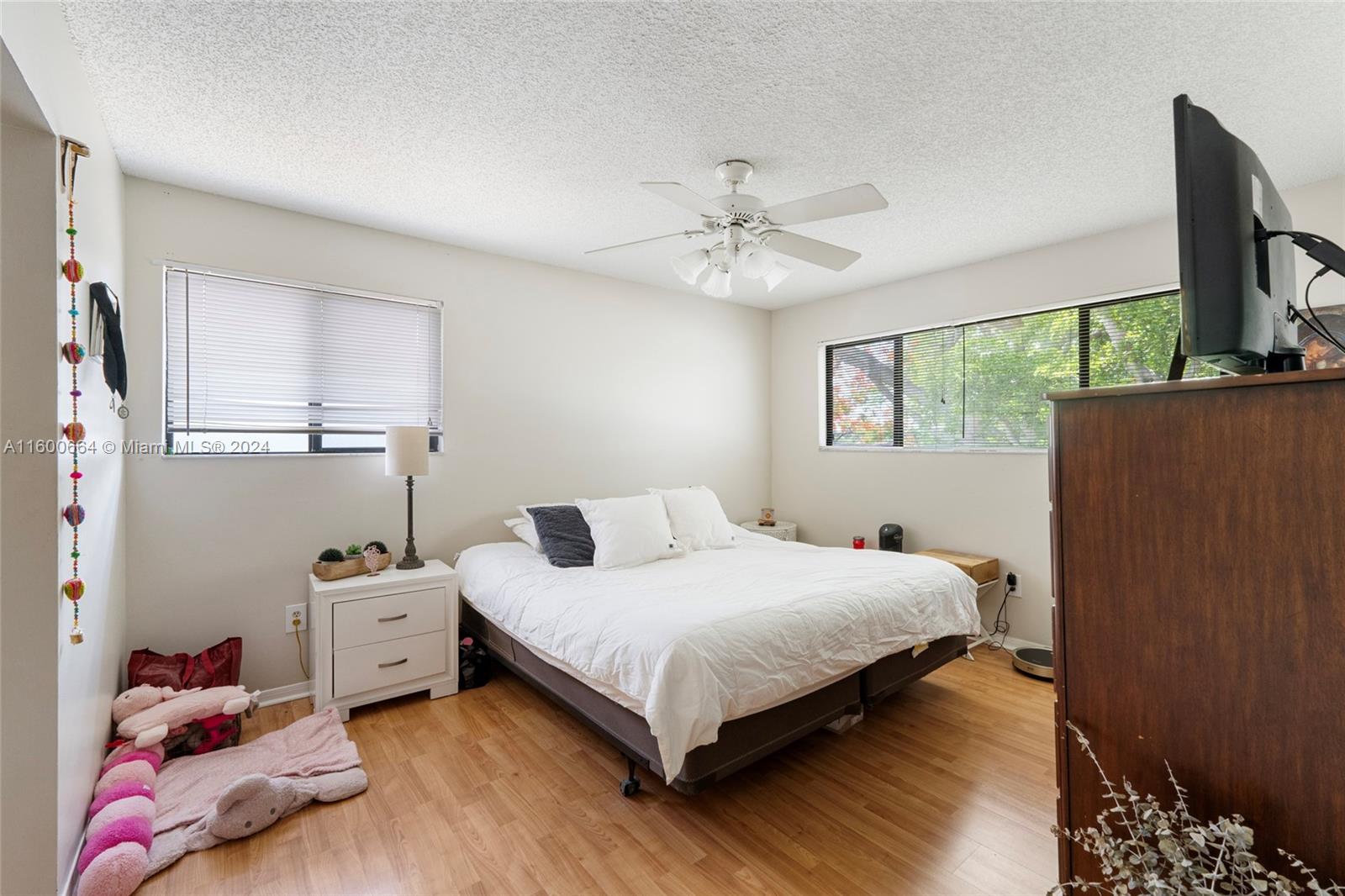 9723 Hammocks Boulevard, Unit 202 Miami, FL 33196 - Photo 9 of 15 a bedroom with a bed and a flat tv screen on dresser