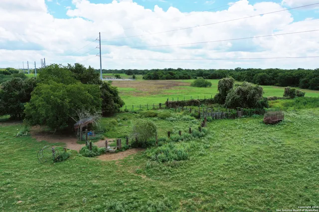 a view of a green field with wooden fence