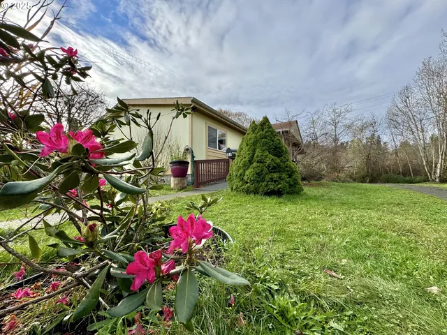 a backyard of a house with lots of flower plants