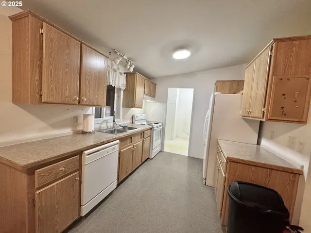 a kitchen with a sink a refrigerator and cabinets