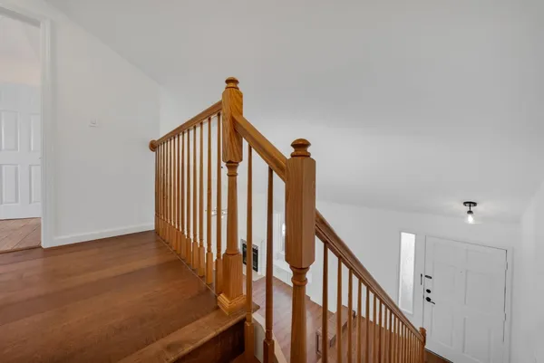 a view of staircase with railing and white walls