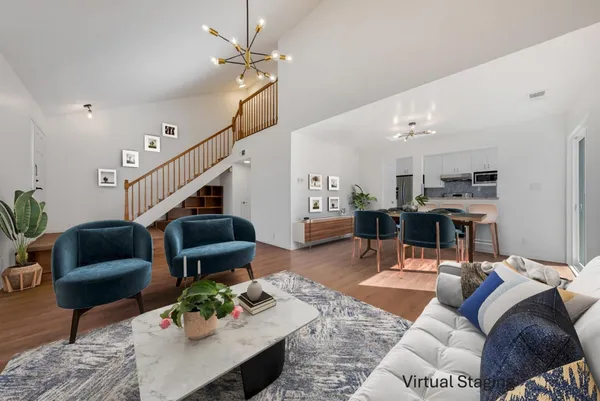 a living room with furniture kitchen view and a chandelier