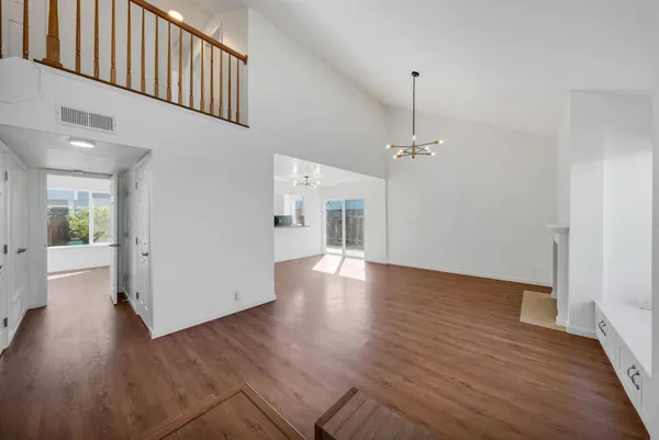 a view of a room with wooden floor fireplace and windows
