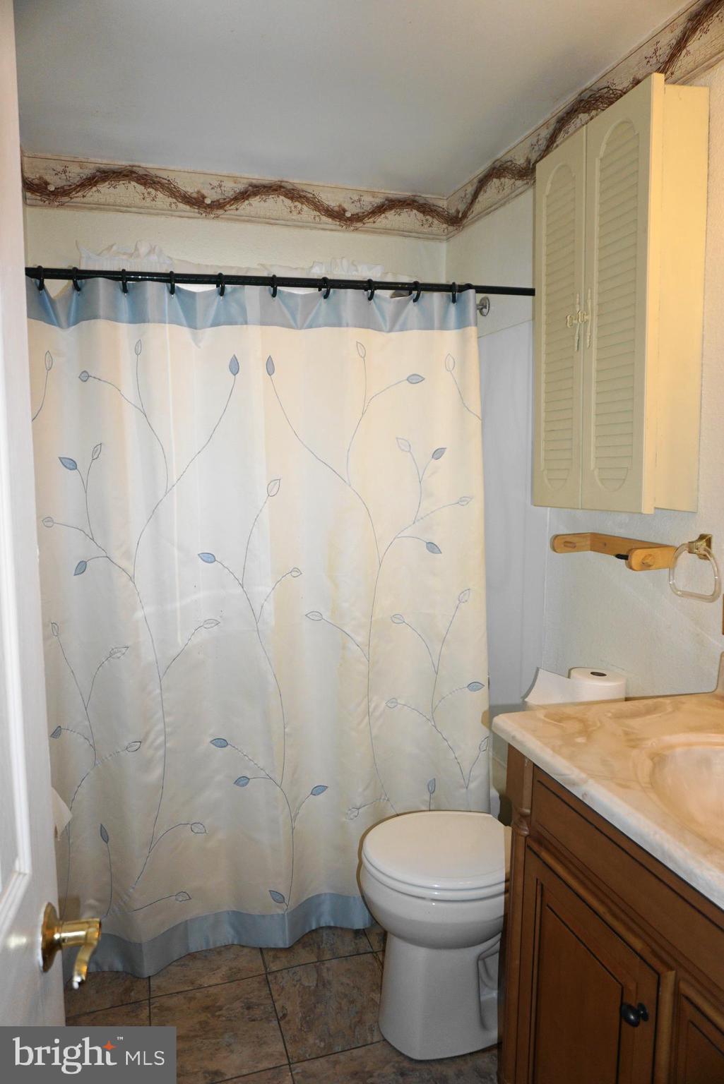 3007 Ogletown Road Newark, DE 19713 - Photo 17 of 25 a bathroom with a shower curtain and a toilet