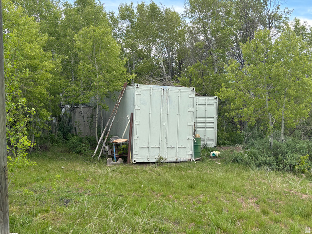 6476 Stauffer Road, Unit 4 Montpelier, ID 83254 - Photo 9 of 17 Two shipping containers on a grassy lot, surrounded by abundant deciduous trees