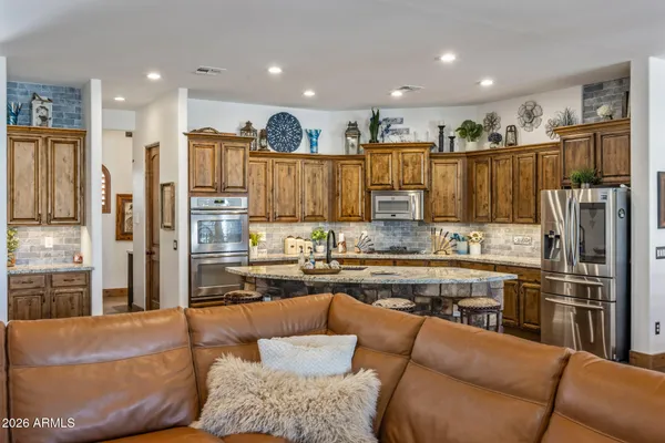 a large living room with stainless steel appliances granite countertop a couch and a large window
