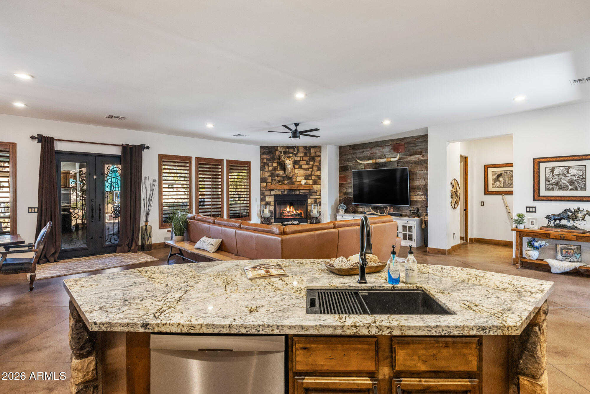 1406 West Joy Ranch Road Phoenix, AZ 85086 - Photo 19 of 58 a living room with granite countertop couches a coffee table and flat screen tv