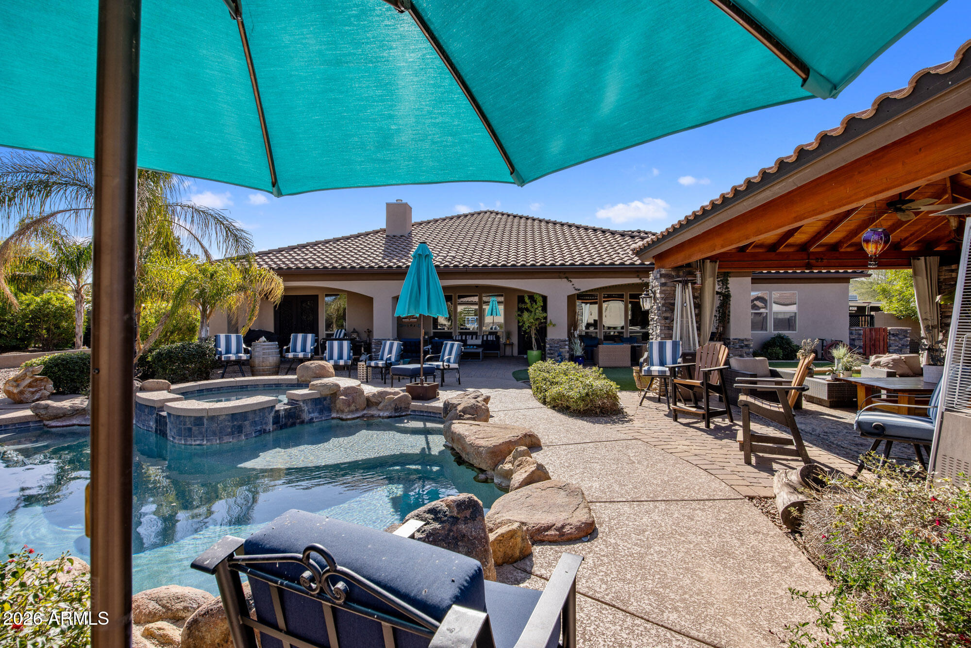 1406 West Joy Ranch Road Phoenix, AZ 85086 - Photo 37 of 58 a view of a patio with table and chairs under an umbrella