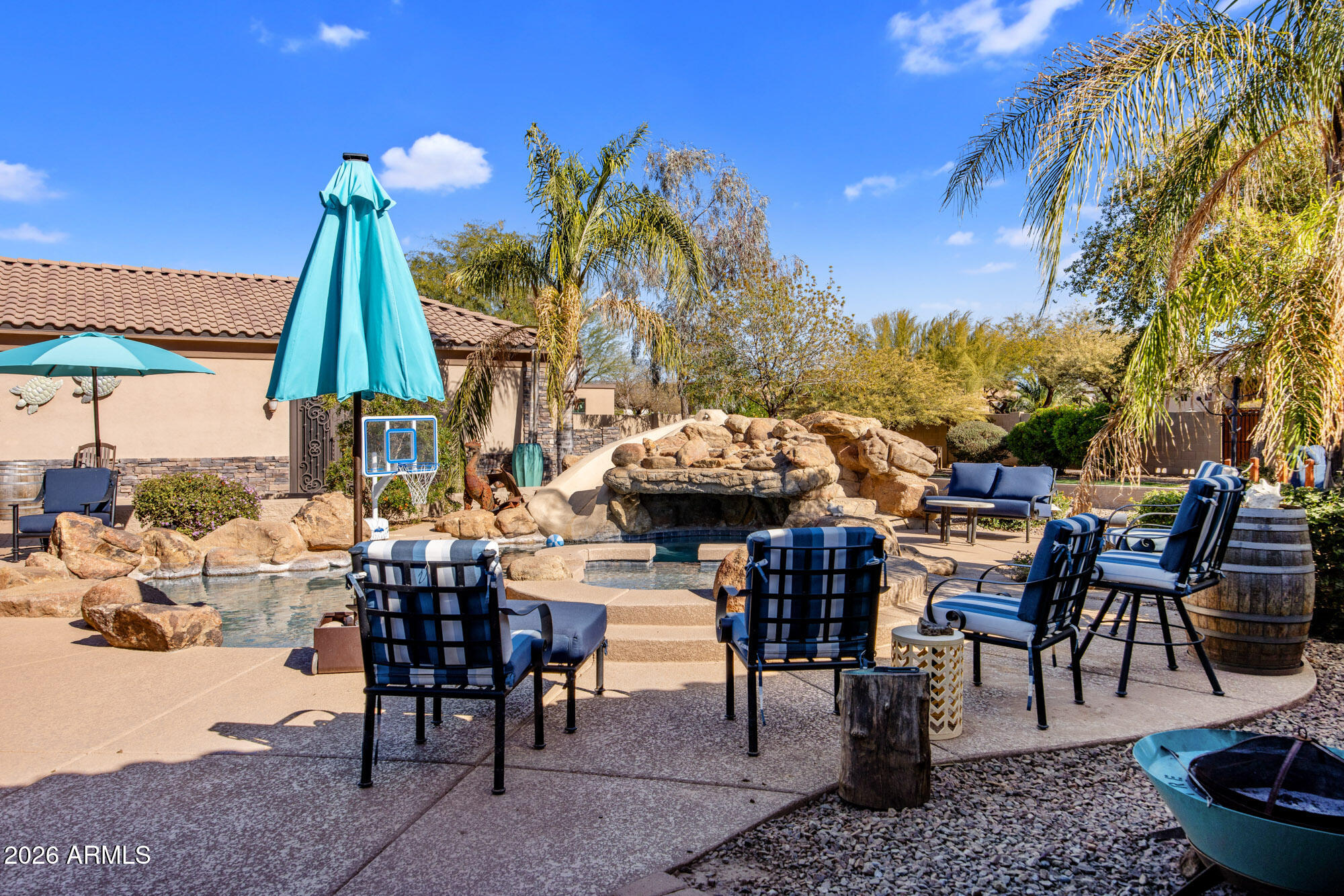 1406 West Joy Ranch Road Phoenix, AZ 85086 - Photo 49 of 58 a view of a patio with table and chairs potted plants and a palm tree