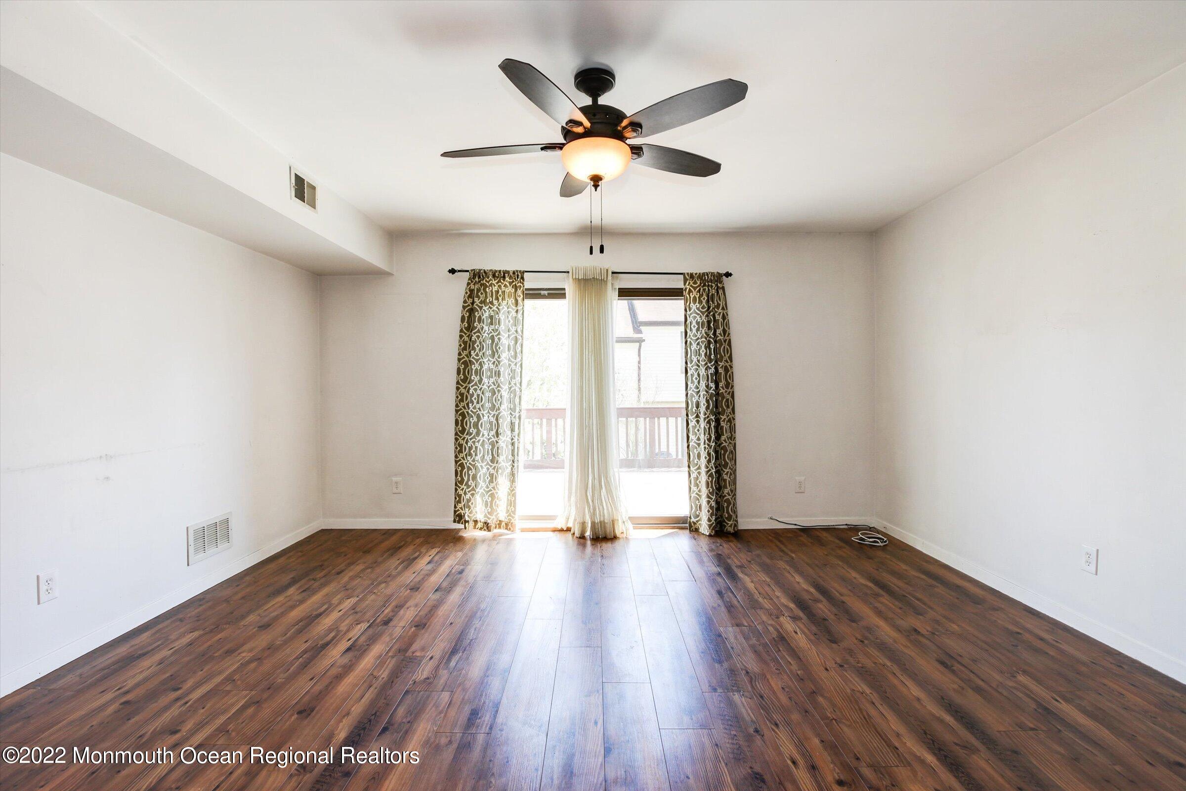 51 Queens Way Englishtown, NJ 07726 - Photo 11 of 25 an empty room with wooden floor and windows
